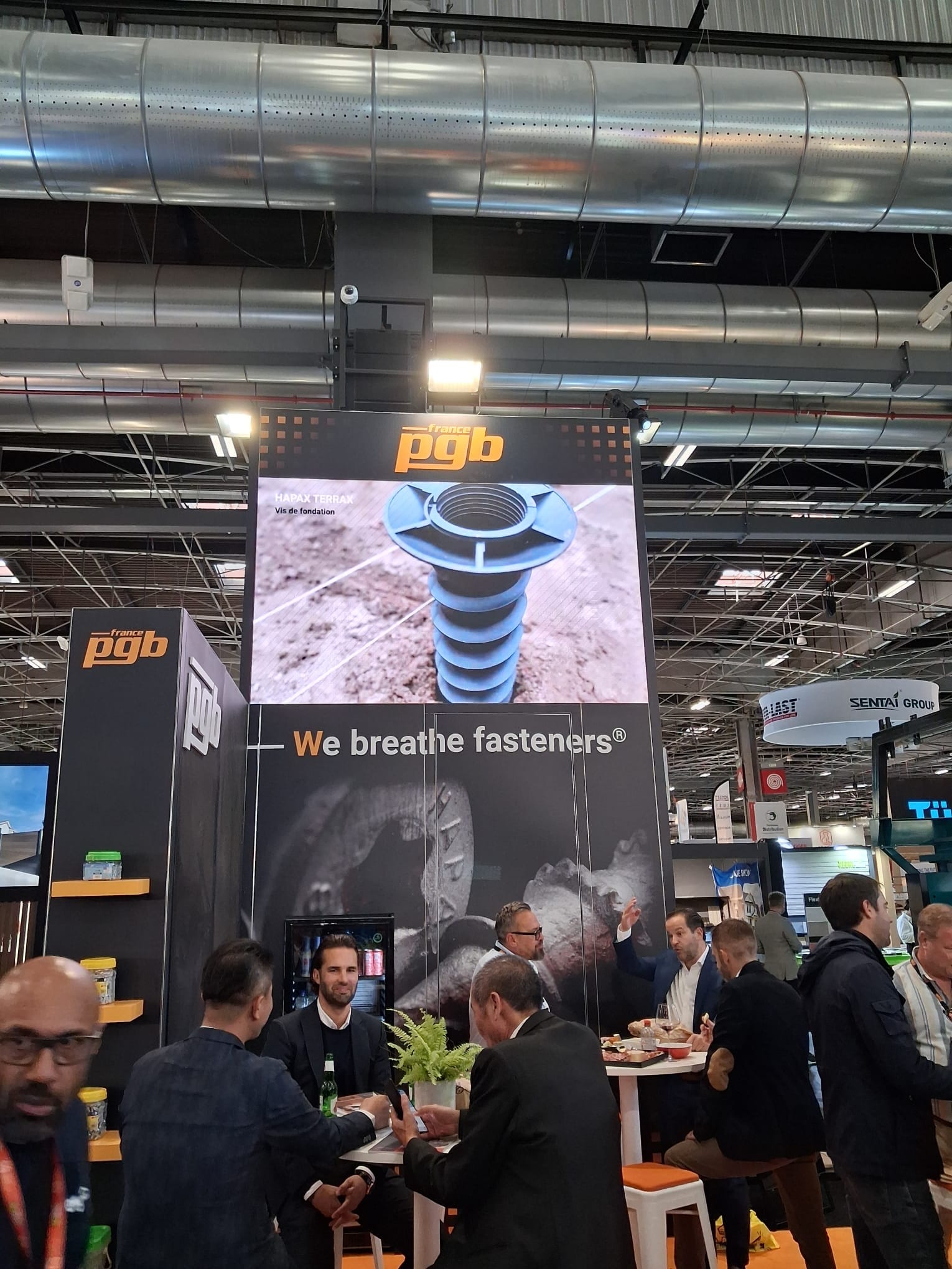 Tour LED verticale du stand PGB France affichant un produit de fixation